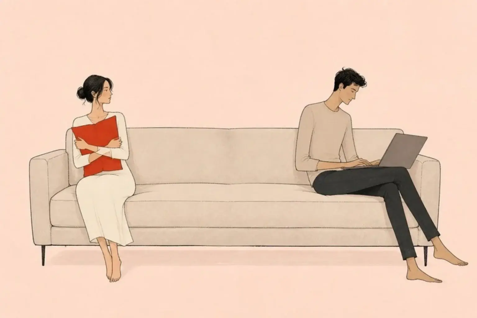 My husband does not love me any more: a woman holds a red cushion while her husband works on his laptop at the other end of the sofa